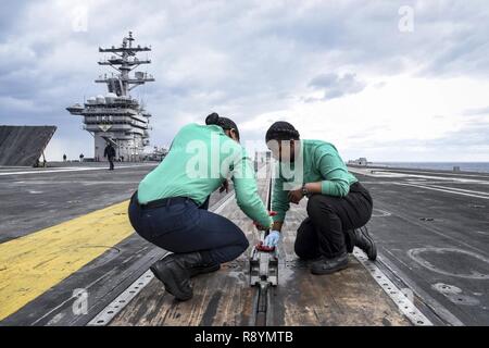 Atlantischer Ozean (18. März 2017) der Luftfahrt Bootsmann Mate (Ausrüstung) Airman Wanda Ingram, von Dallas, Links, und Flieger Paige Boyd, aus New Orleans, führen Wartungsarbeiten an einem Dampfgetriebenen Katapult auf dem Flugdeck der Flugzeugträger USS Dwight D. Eisenhower (CVN 69) (IKE). Ike ist derzeit Flugzeugträger Qualifikationen während der lebenserhaltung Phase des optimierten Flotte Notfallplan (OFRP). Stockfoto