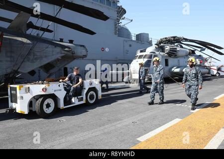 VALENCIA, Spanien (19. März 2017) Segler bereiten einen MH-53 Super Hengst Hubschrauber zu bewegen, die "Blue Knights" von Marine Medium Tiltrotor Squadron 365 (Verstärkt) zugeordnet, über das Flight Deck der Amphibisches Schiff USS Bataan (LL 5) als das Schiff fährt in Valencia, Spanien, 19. März 2017. Das Schiff ist derzeit mit den Bataan Amphibious Ready Gruppe zur Unterstützung der Maritime Security Operations und Theater Sicherheit Zusammenarbeit in den USA 6 Flotte Bereich der Operationen eingesetzt. Stockfoto