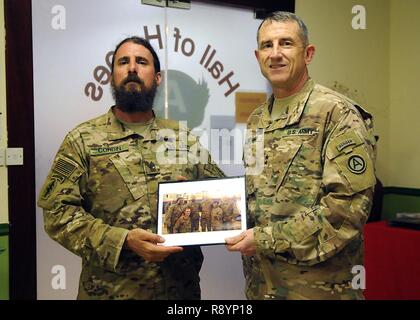 Generalmajor William Hickman (rechts), Stellvertretender kommandierender General für die US-Army Central, präsentiert ein Foto für die pensionierten Master Sgt. Christopher Corbin, 7th Special Forces Group, nach einem Abendessen für den Betrieb Ordentliche Soldaten hielten, 19. März Camp Arifjan, Kuwait. Corbin ist einer von sechs Soldaten, die in dieser Runde der OPE, das ist ein Programm, dass die Krieger, die auf dem Schlachtfeld verwundet bringt und damit erlaubt Ihnen, "ordnungsgemäß verlassen, "Theater teil. Ein Improvised Explosive Device verursacht eine Unter-knee Amputation für die Metairie, Louisiana, Eingeborener, während er in Afghanistan diente, Februar 2011. Stockfoto