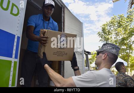 Us Air Force Oberstleutnant Steven Dadd, die 12 Expeditionary medizinische Operationen Squadron stellvertretender Kommandant von der 959th Medical Group im Joint Base San Antonio-Fort Sam Houston, Texas eingesetzt, hilft angereicherte Lebensmittel durch eine nicht gespendet - Regierung Organisation zur Unterstützung der neuen Horizonte 2017 in Azua, Dominikanische Republik, 5. März 2017 entladen. Neue Horizonte ist eine medizinische Bereitschaft Ausbildung ausüben. Angereicherte Lebensmittel verringern das Auftreten von nährstoffmangel und wurden bei Patienten, die Anzeichen von Unterernährung verteilt. Stockfoto
