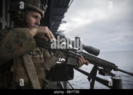 Staff Sgt. Mathew Tippett, ein Scout Sniper mit Scout Sniper Platoon, Waffen, Bataillon Landung Team 2nd Battalion, 5th Marines, 31 Marine Expeditionary Unit, simuliert ein Test Feuer über den Laufsteg der USS BONHOMME RICHARD (LHD6), während der ein Schiff besuchen, Board, Durchsuchung und Beschlagnahme Übung in den Pazifischen Ozean, 17. März 2017. 31 MEU führt VBSS als Teil von 17,1 der 31 MEU Feder Patrouille der Asien-Pazifik-Region. Wie das Marine Corps' nur kontinuierlich vorwärts eingesetzt, die 31 MEU - Logistik Team bietet eine flexible Kraft, bereit, auf eine breite Palette o durchführen Stockfoto