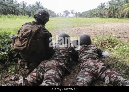 Cpl. Robert Piedra, ein rifleman mit speziellen Zweck Marine Air-Ground Task Force - Krisenmanagement - Afrika, beobachtet Soldaten mit der Kamerunischen Naval Commando Firma Feuer die PKM Maschinengewehr an Isongo, Limbe, Kamerun, 24.02.24. 2017. Diesen Marinen dienen als bodenkampf Element für SPMAGTF-CR-AF, ermöglicht den Schutz von US-Personal, Eigentum und Interessen in Europa und Afrika. Stockfoto