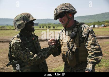 Staff Sgt. Ivan Colina, schwere Ausrüstung Chief mit speziellen Zweck Marine Air-Ground Task Force - Krisenmanagement - Afrika, grüßt ein Soldat aus dem Uganda People's Defence Force, bevor ein live-fire Sortiment am Lager Singo, Uganda, 8. März 2017. Us-Marines mit SPMAGTF-CR-AF unterrichtete Klassen und in der praktischen Anwendung Übungen teilgenommen, unterstützende Funktionen, unvorhergesehene Ereignisse und die Zusammenarbeit im Bereich der Sicherheit in den USA Afrika Befehlsbereich der Verantwortung. Stockfoto