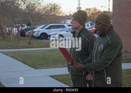 Us Marine Corps Sgt. Maj. Johnnie M. Hughes, rechts, Sergeant Major, Sitz und Support Battalion (H&S Bn), Marine Corps Installationen Osten (MCIEAST), liest eine Unit citation nach in einem H&S Bn motivationale ausführen, Camp Lejeune, N.C., 17. März 2017 teilnehmen. Der Lauf wurde angeordnet, die Kameradschaft und der Zusammenhalt innerhalb von H&S Bn zu errichten. Stockfoto