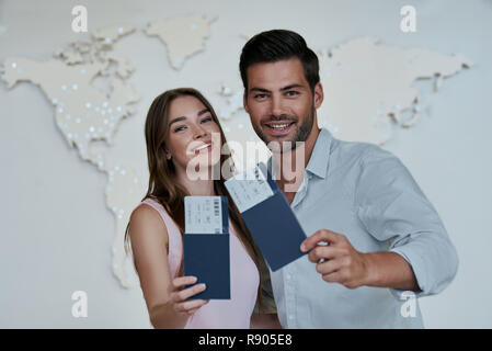 Portrait von freudiger froh Paar hält Reisepass mit fliegenden Karten in den Händen Stockfoto