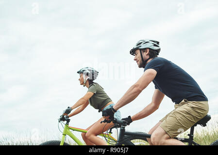 Junge Paare sind Radfahren auf fatbikes und Helme. 7/8-Foto Stockfoto