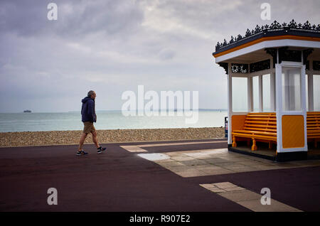 Meer Tierheim im Winter an der Küste von Southsea mit einsamen Mann in Shorts und Puffer Jacke Stockfoto