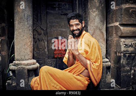 Naggar (Kullu Tal), Nord Indien - Juli 2013. Lächelnd indischen Brahmanen. sitzen in der Nähe der Tempel von Lord Krishna. Die Hände gefaltet in namaste Mudra. Stockfoto