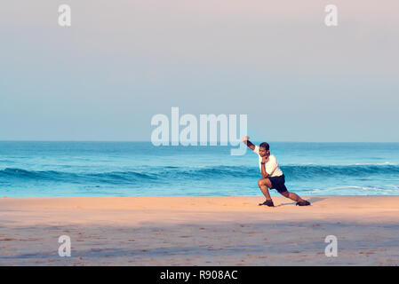 Cochin, Kerala, Indien - 30. November 2017: Indische Mann tun morgen Yoga Asana und körperliche Übungen am Strand. Cochin, Kerala, Südindien. Stockfoto