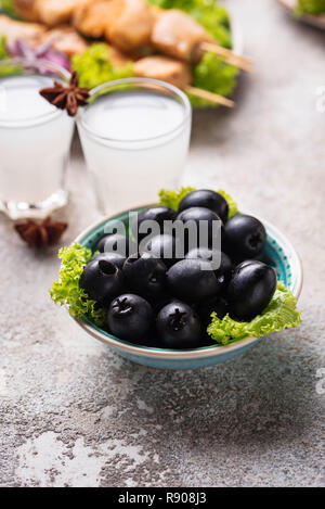 Schwarze Oliven und traditionelle griechische Gerichte Stockfoto