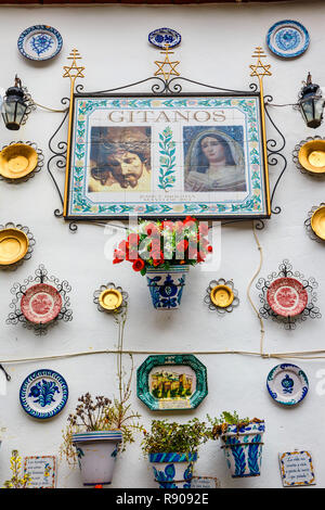 Granada, Spanien, April 06, 2018 :: Fassade eines traditionellen Hauses mit dekorativer Keramik Teller und Töpfe von bunten Blumen im historischen Viertel Albaicin n Stockfoto