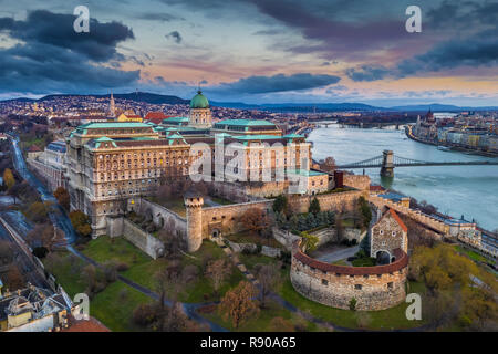 Budapest, Ungarn - Luftbild Panorama auf die Budaer Burg Royal Palace und Széchenyi Kettenbrücke in der Abenddämmerung mit bunten Wolken und Himmel Stockfoto