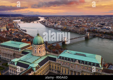 Budapest, Ungarn - Luftbild der Budaer Burg Königspalast mit Széchenyi Kettenbrücke, Parlament und bunten Wolken im Golden sunrise Stockfoto