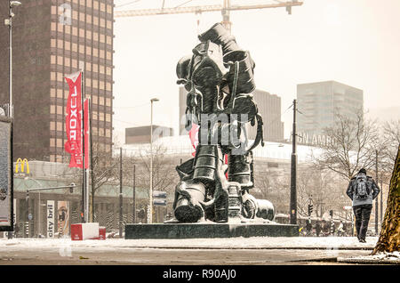 Rotterdam, Niederlande, 11. Dezember 2017: Ein einsamer Fußgänger übergibt die Kaskade Skulptur auf Churchillplein Square an einem kalten Tag im Winter Stockfoto