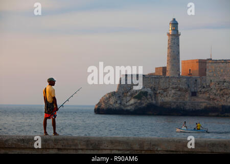 Ein Fischer auf dem Geländer auf dem Malecon am Eingang des Hafens von Havanna, Kuba. Stockfoto