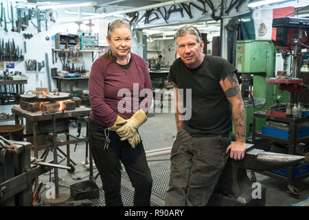 Zwei Schmiede, einem kaukasischen Mann und die Frau in Ihre Werkstatt. Stockfoto