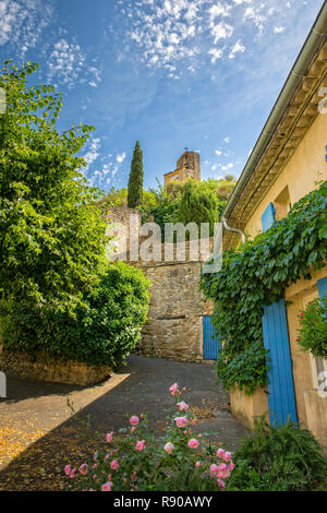 In Lourmarin, Provence, Luberon, Vaucluse, Frankreich - Mai 30, 2017: idyllische Gasse mit Blick auf den alten Kirchturm in Lourmarin Stockfoto