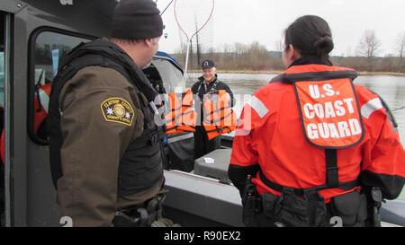 Ein Fischer auf dem Columbia River zeigt Schwimmwesten zu einem Clatsop County Sheriff's Deputy und Küstenwache lt Adriana Gaenzle während einer Dual-Agentur Strafverfolgung Patrouille durch die Offiziere von der Coast Guard Sektor Columbia River durchgeführt und das Büro der Clatsop County Sheriff's, 4. März 2017. Personal von der Coast Guard Sektor Columbia River Durchsetzung regelmäßig gemeinsam mit Abgeordneten von Office die Clatsop County Sheriff's die Sicherheit der Öffentlichkeit zu gewährleisten, während sie auf dem Wasser. Stockfoto