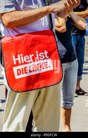 Im mittleren Alter Mann mit Schultertasche mit der Inschrift: "Hier ist DIE LINKE" Stockfoto