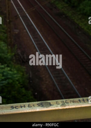 Graffito auf der Attika über eine Bahnlinie, Text: s .. t , Stockfoto