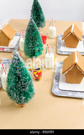 Kinder Partei kleine Lebkuchenhäuser mit Bonbons zu verzieren. Stockfoto