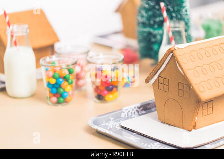 Kinder Partei kleine Lebkuchenhäuser mit Bonbons zu verzieren. Stockfoto