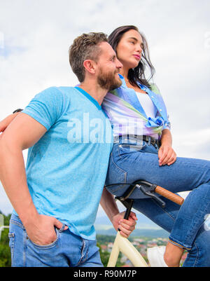 Warum Frauen mehr angezogen biker Jungs. Mädchen sitzen am Lenker seines Fahrrades. Man bärtige macho Fahrten Freundin auf seinem Fahrrad. Idee für ein romantisches Date mit dem Fahrrad. Mädchen mag er reitet ihr am Lenker. Stockfoto