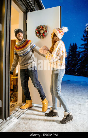 Junges Paar in den schön eingerichteten Haus durnig der Winterurlaub in den Bergen kommenden Stockfoto
