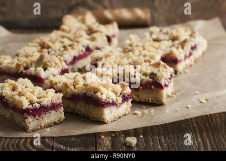 Hausgemachte gebackene Himbeere bars auf rustikalen Holztisch, Nahaufnahme, selektiven Fokus Stockfoto