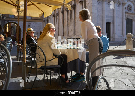 Lucca, Italien: Kellnerin serviert Paar Kaffee in Piazza Stockfoto