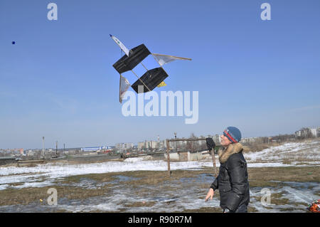 Kovrov, Russland. 28. März 2010. Junger Mann startet Kite ist ähnlich zu dem Modell einer Passagiermaschine Stockfoto