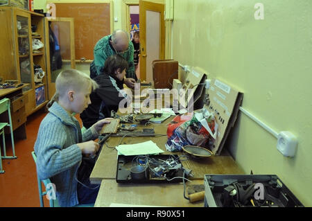 Kovrov, Russland. 2. März 2011. Mentor der Abschnitt radio Kinderclub "Atlas" hilft dem Schüler sammelt elektronische Geräte Stockfoto