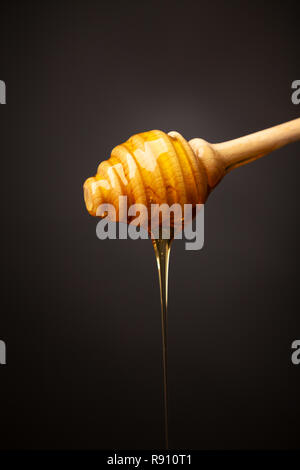 Honig tropft von einer hölzernen Honig Pendelarm. Stockfoto