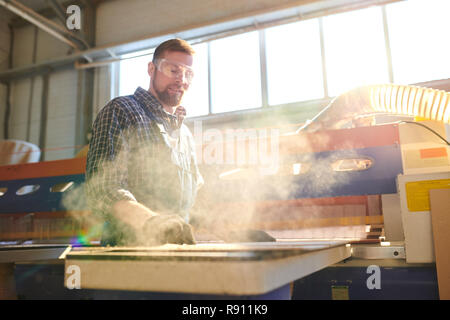 Mitarbeiter arbeiten in staubiger workshop Bärtigen Stockfoto