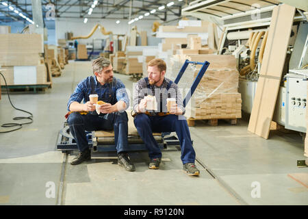 Stattliche männliche Arbeiter in Uniform chatten bei Bruch Stockfoto