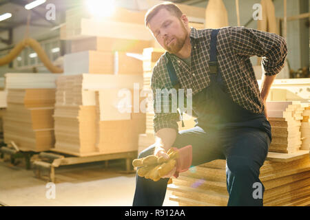 Arbeiter in Schmerz in zurück Stockfoto