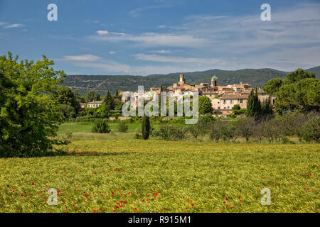 Lourmarin, einem kleinen Dorf im Luberon. Bereich der Weizen und Mohn mit Blick auf das idyllische Dorf Lourmarin, Provence, Luberon, Vaucluse, Frankreich Stockfoto