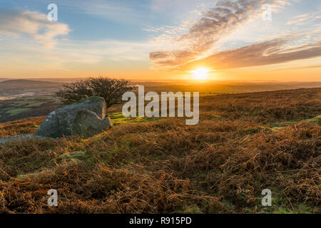 Sonnenaufgang über Bodmin Moor mit schönen bewölkt Golden Sky und Granitblock, Caradon Hill, Cornwall, Großbritannien Stockfoto