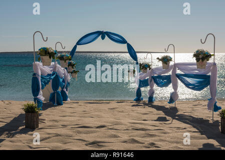 Setup von Hochzeit ehe Gang mit Vorhängen und Bogen auf Sandy Tropical Beach Paradise Ocean Hintergrund zu öffnen. Stockfoto