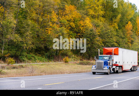 Blue Big Rig Tag cab Amerikanischen Motorhaube Semi Truck Traktor Transport hohe Schüttdichte gerippte Auflieger mit Spoiler an der vorderen Wand auf der Herbst ro läuft Stockfoto