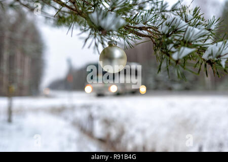 Golden Christmas Ball auf den verschneiten Tannen Filiale neben der Autobahn. Stockfoto