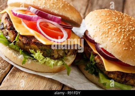 Veggie Burger mit frischem Salat, Zwiebeln, Tomaten und Cheddar Käse close-up auf dem Tisch. Horizontale Stockfoto