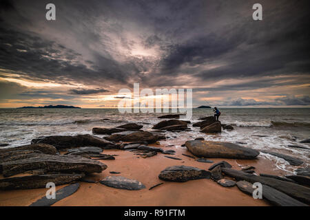 Mann angeln in den letzten Strahlen der Sonnenuntergang am Meer, Thailand Stockfoto