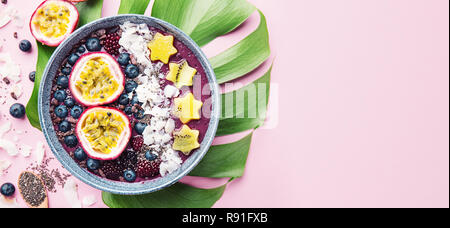 Lecker appetitlichen Smoothie acai Schale von Brombeeren und wilde Beeren, mit Passionsfrucht, Kokosflocken dekoriert, und Kakao Nibs. Serviert Stockfoto