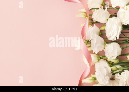 Blick von oben auf die weiß blühende Rosen und Pink Ribbon auf rosa Hintergrund platziert. Stockfoto