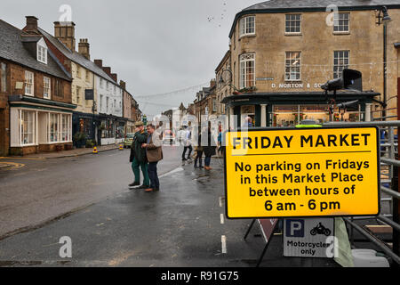 Hinweis über Parkplätze am Freitag marktplatz Neben der Haupteinkaufsstraße (Hohe Straße) in Uppingham, Rutland, England, auf einer nassen Wintertag. Stockfoto