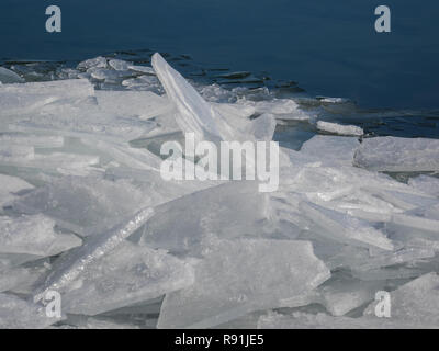 Gezackte Platten von gebrochenem Eis schwimmen im offenen Wasser am Ufer des Lake Superior im nördlichen Minnesota. Stockfoto