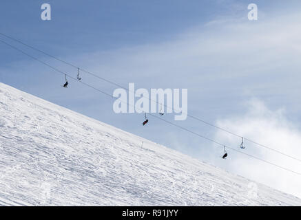 Snowy off-piste Skipiste mit Spuren von Skiern und Snowboards und Sesselbahn gegen Himmel mit Wolken. Kaukasus Berge im Winter, Georgien, Region G Stockfoto