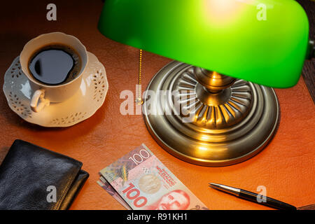 Neuseeland Dollar, auf einer stilvollen Schreibtisch Leuchten mit einem Banking Lampe Stockfoto