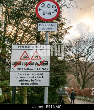 Zeichen verlassen Grasmere Dorf Warnen von Long/grosse Fahrzeuge zu vermeiden, folgende Sat Nav, der sich die steilen und schmalen roten Bank Road. Stockfoto